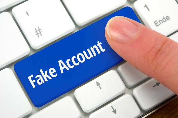 Finger drück auf blaue Taste mit der Aufschrift Fake Accounts