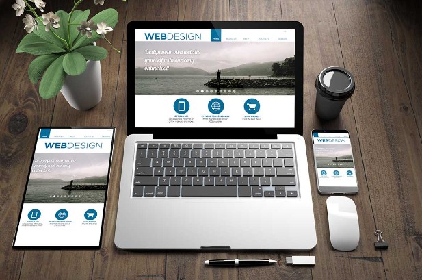 blumen, tablet, smartphone und laptop stehen auf einem holztisch