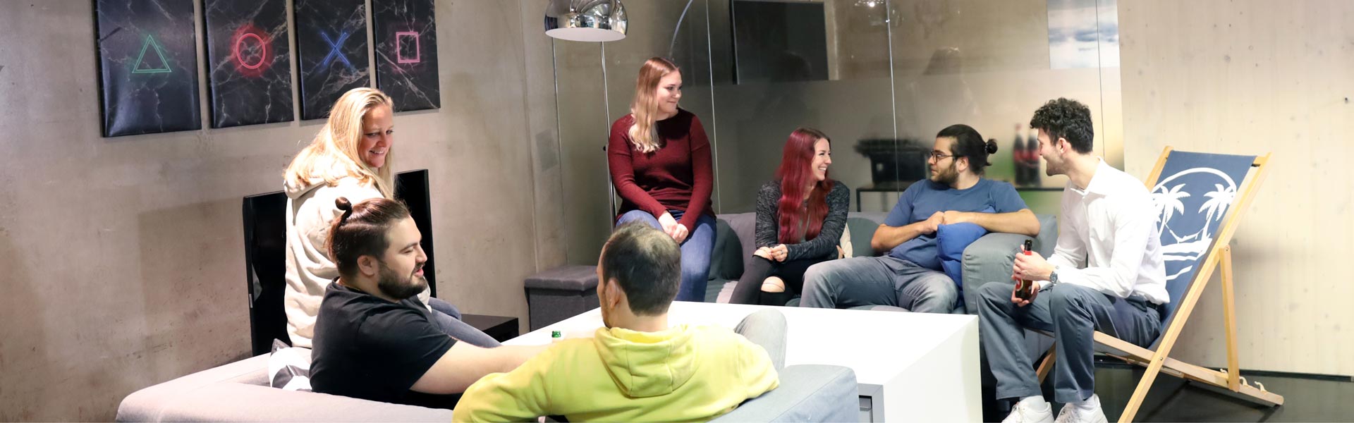 PS Marketing Team, das auf den Sofas im Büro sitzt und sich nach Feierabend entspannt unterhält