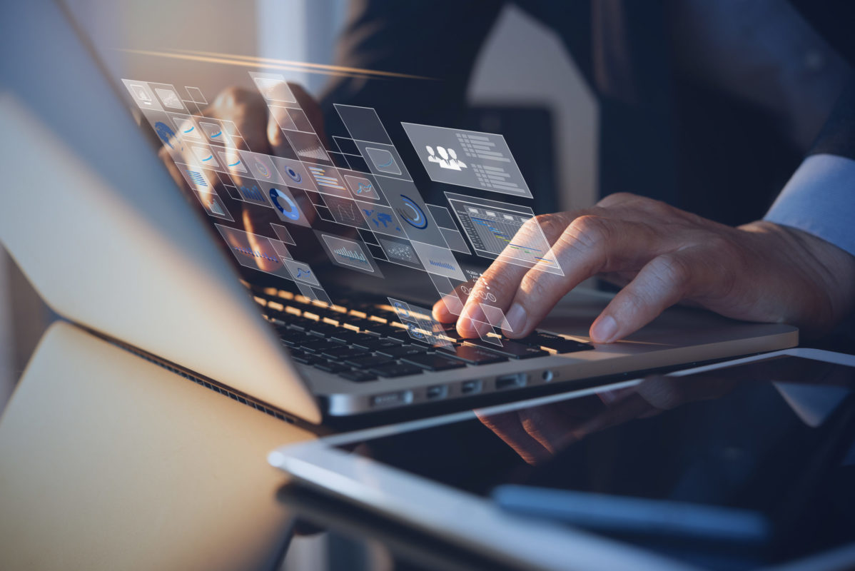 Person, die Laptop als Digital Workplace nutzt und dabei verschiedene Diagramme auswertet