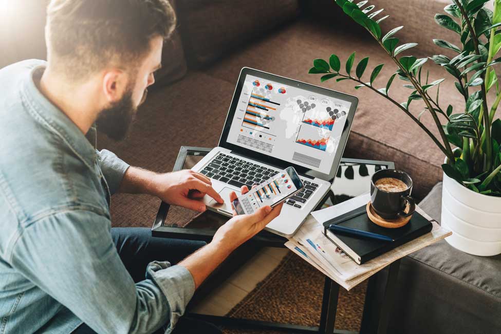 Mann, der an seinem Laptop den Erfolg seiner ersten Schritte im Online-Marketing prüft