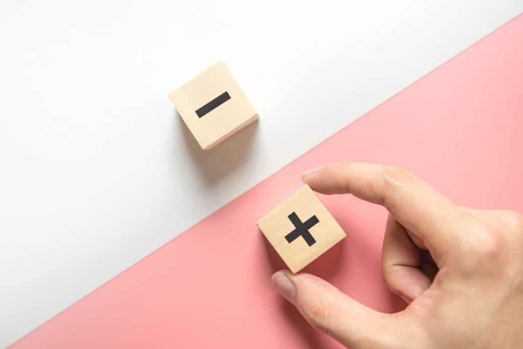 Hand und zwei Würfel mit einem Plus- und Minus-Zeichen als Symbol für die Vor- und Nachteile des Display Advertisings