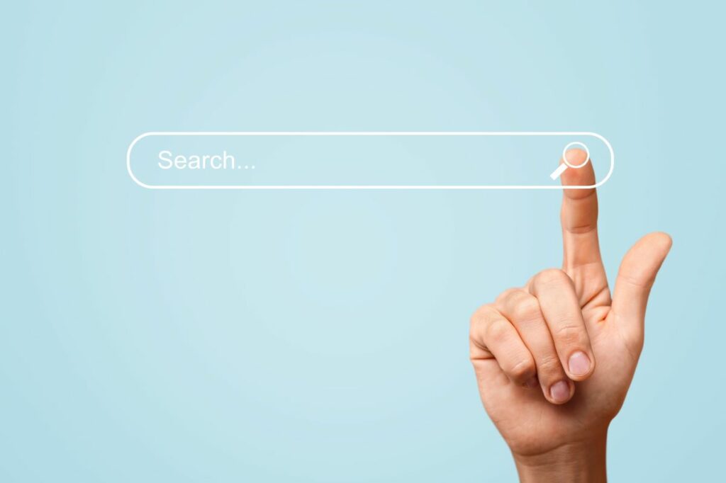 Finger drückt Lupen-Icon in der Suchleiste von Google